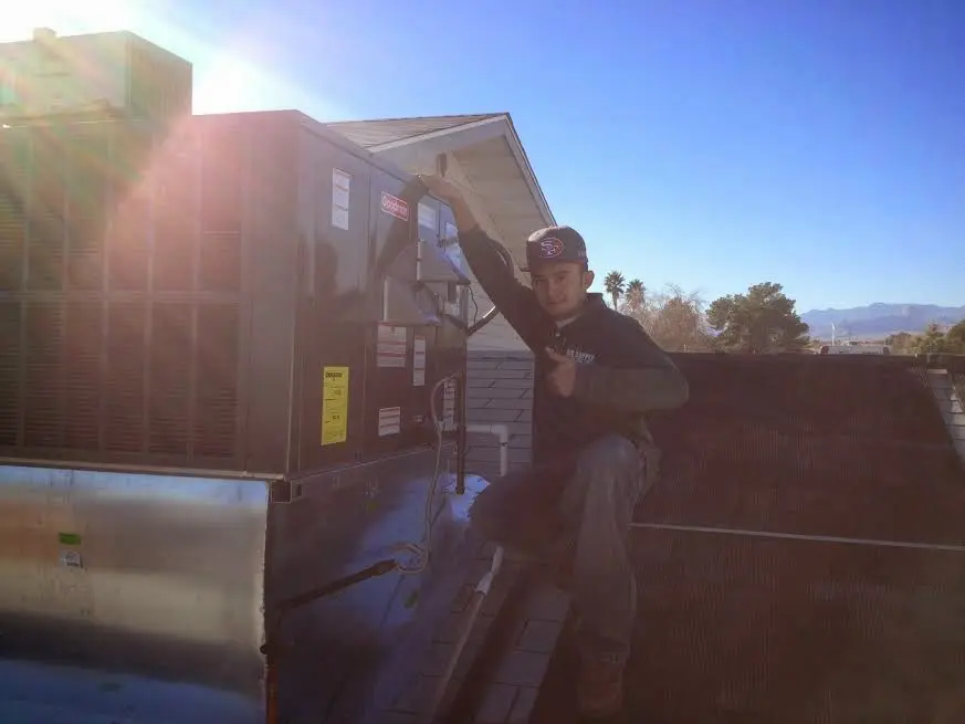 HVAC technician performing Boiler Repair on a rooftop unit in Verdigris
